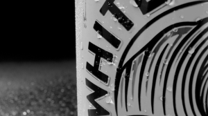 Macro close-up of White Claw Hard Seltzer can typography with water droplets highlighting texture and refreshment
