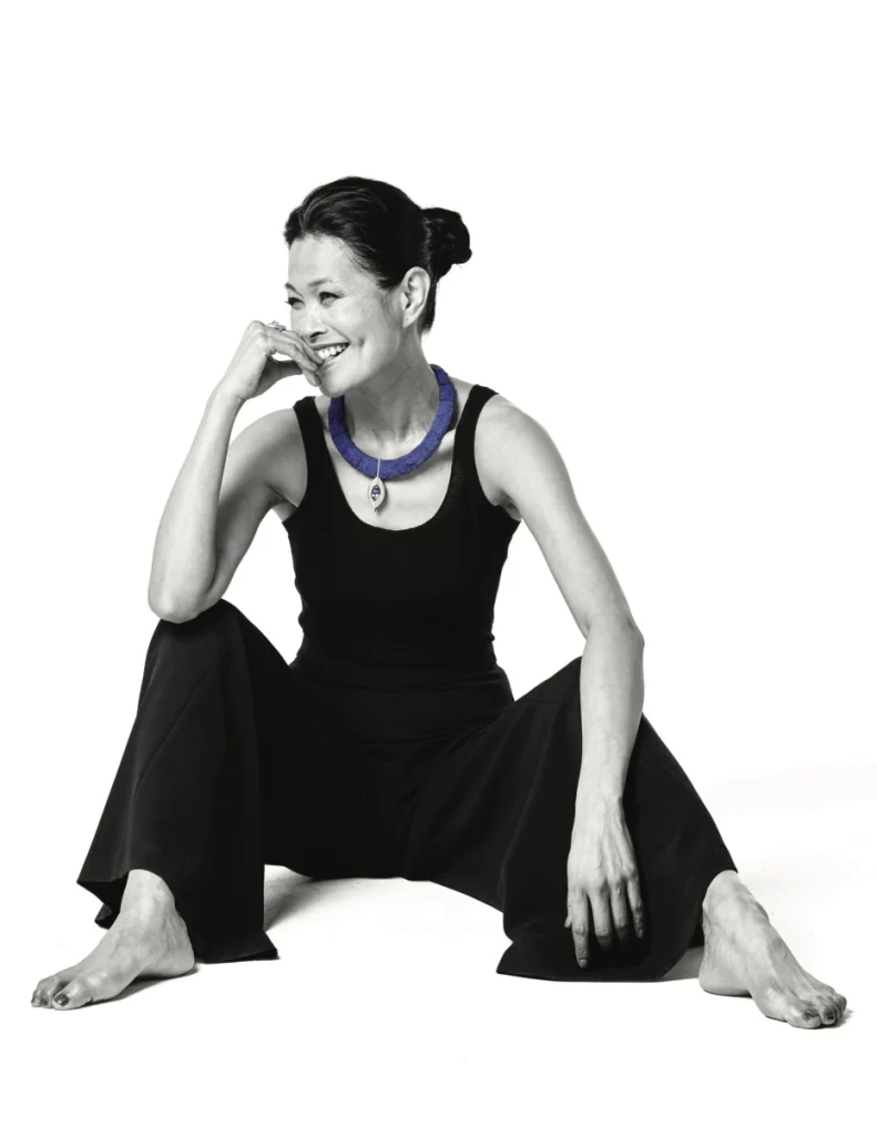 Black-and-white portrait of a woman wearing a gemstone necklace, representing modern craftsmanship and ethical luxury for the American Gem Trade Association.