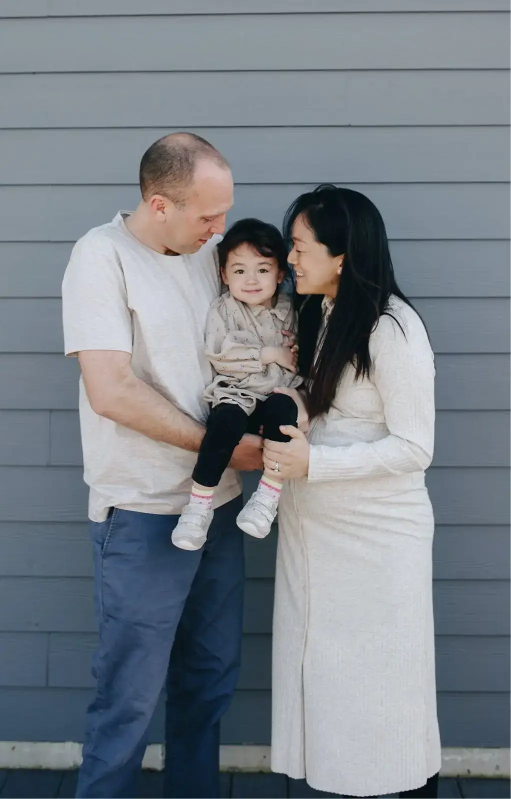 Think Small family photo showing parents holding their child, highlighting trust, care, and early childhood resources for families.
