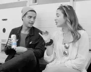 Two people sitting and talking while holding White Claw Hard Seltzer cans in a casual, candid lifestyle moment.