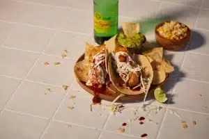Social truths campaign featuring tacos and a green beverage bottle arranged on a tiled surface.