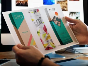 Designer reviewing colorful spirits packaging concepts, representing AI in creative agencies.