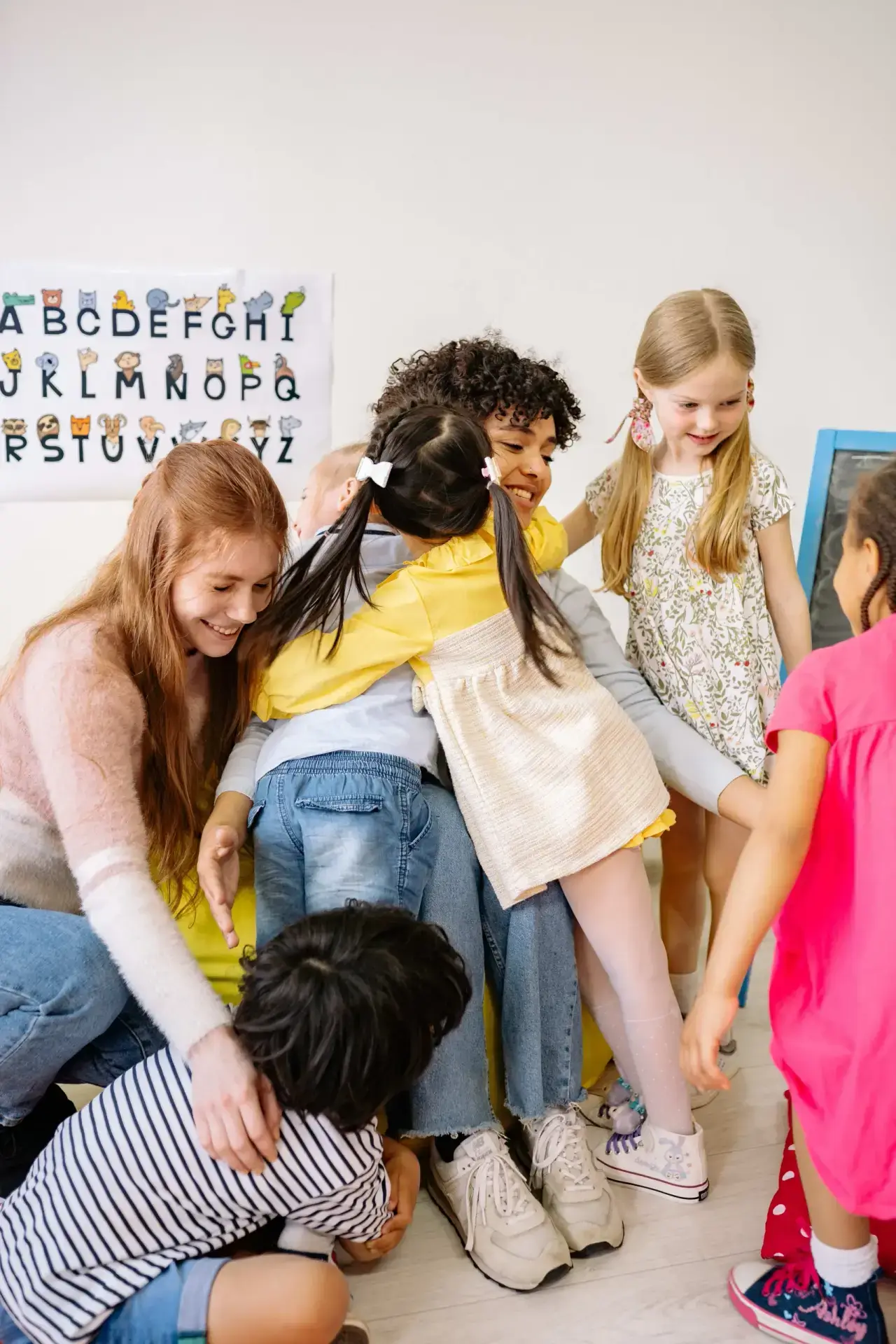 Think Small early childhood classroom photo showing children playing and interacting with a caregiver in a bright learning space.