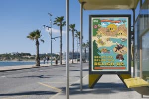 Campaign poster displayed at a seaside bus stop, featuring playful snack-inspired characters and bold colorful branding - Agency Squid consumer goods.